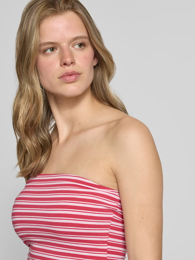 Frauenmodel trägt schmal geschnittenes Bandeau-Top von REVIEW in Rot-Weiß gestreift, elastisches Baumwoll-Elasthan-Mix, Nahaufnahme Oberkörper.