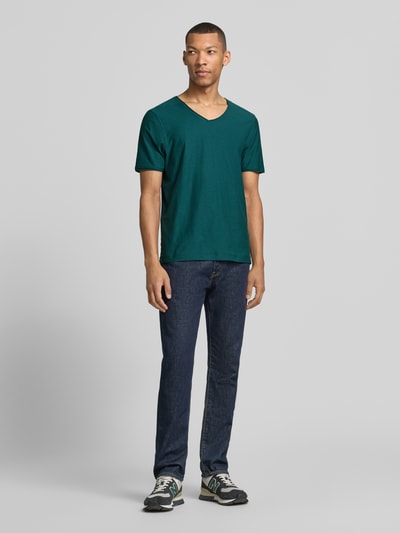 Männermodel trägt Regular Fit T-Shirt mit V-Ausschnitt von MCNEAL in Grün, Reine Baumwolle, Rollsaum, Rückenlänge 70 cm, Ganzkörperansicht von vorne.