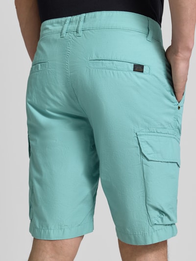 Männermodel trägt Bermudas mit Cargotaschen van camel active uit pure katoen in regular fit, cargozakken, label-detail, detailopname achterkant