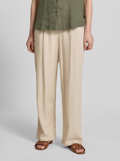 Frauenmodel trägt Loose Fit Weite Hose aus Viskose-Leinen-Mix Modell 'JESMILO' von Vero Moda in Beige mit Bundfalte und Eingrifftaschen, Nahaufnahme Unterkörper.