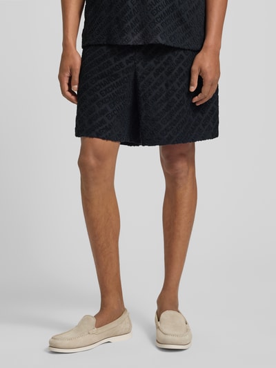 Männermodel trägt Shorts mit Logo-Muster und elastischem Bund von ARMANI EXCHANGE, schwarzer Baumwoll-Elasthan-Mix, regular fit, Nahaufnahme Unterkörper