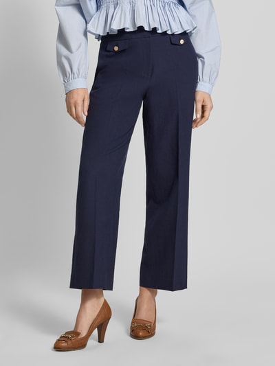 Vrouwenmodel draagt Straight Fit Leinenhose mit Viskose-Anteil Modell 'Alara' van SEDUCTIVE, donkerblauw, met persvouwen, paspelzakken, sierknopen, rechte pijpen, linnenmix, detailopname onderlichaam, context: dames linnenbroek, elastische linnenmix, taillewijdte 42 cm, binnenbeenlengte 71 cm.