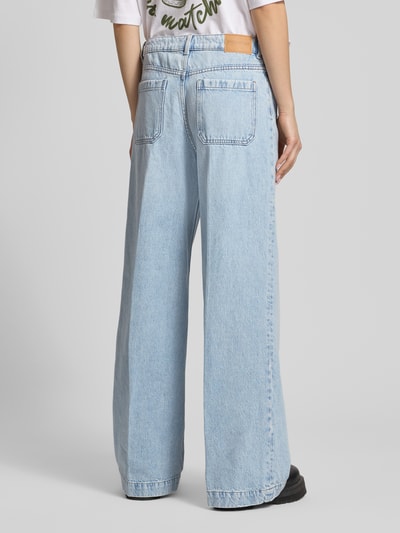 Frauenmodel trägt Wide Leg Jeans mit aufgesetzten Taschen von Review, hellblaue Reine Baumwolle, Bügelfalten, Ganzkörperansicht Rückansicht.