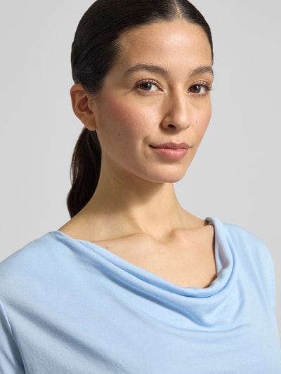 Frauenmodel trägt T-Shirt mit Wasserfall-Ausschnitt von More & More in Hellblau, weicher Viskose-Mix, Nahaufnahme Oberkörper