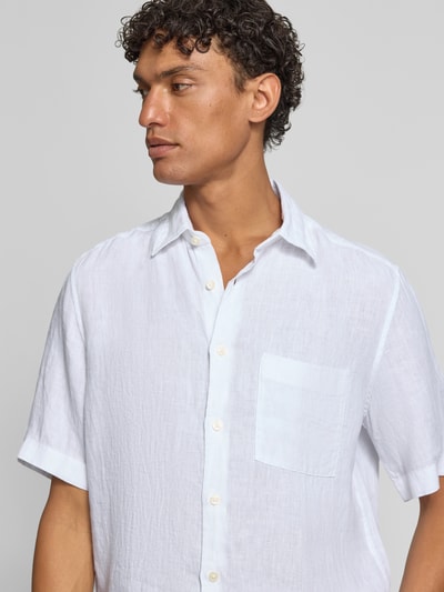Męski model nosi Regular Fit Freizeithemd aus reinem Leinen von Marc O'Polo, efekt: jednolity kolor, krój regular fit, kołnierzyk typu kent, listwa guzikowa na całej długości, naszywka z logo, krótki rękaw, cieniowana przędza, materiał: len; zbliżenie na górę przodu.