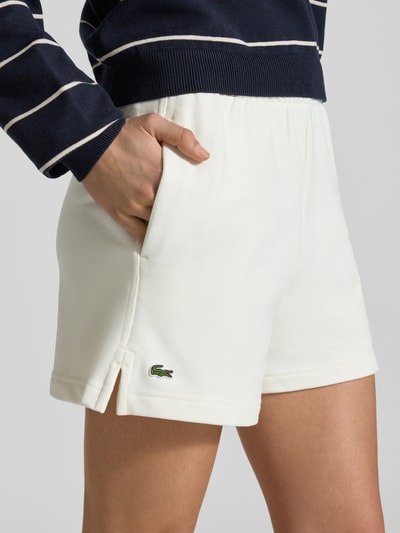 Kobieta modelka nosi Regular Fit Sweatshorts aus reiner Baumwolle von Lacoste, efekt: jednolity kolor, krój regular fit, wyhaftowane logo, tunel, elastyczny ściągacz, wpuszczane kieszenie, bawełna; zbliżenie na górną część nóg