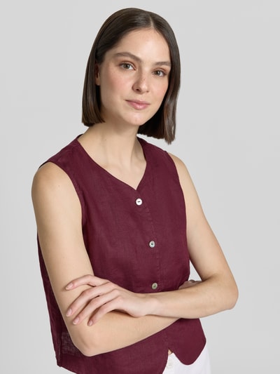 Frauenmodel trägt Leinenweste mit V-Ausschnitt und Knopfleiste von Christian Berg Woman, bordeauxrot, Leinenstruktur, Regular Fit, Nahaufnahme Oberkörper.
