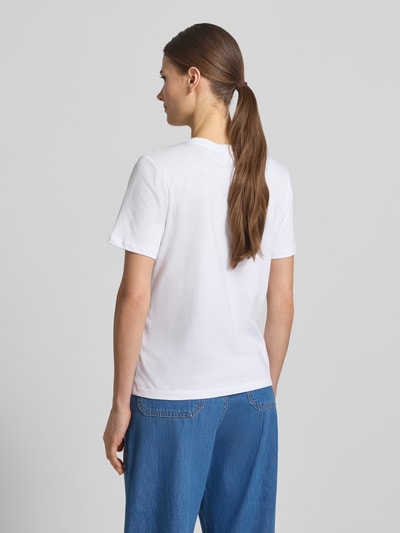 Frauenmodel trägt Regular Fit T-Shirt mit Rüschenbesatz von Comma aus reiner Baumwolle mit Rundhalsausschnitt, Rückenlänge 56 cm, Ganzkörperansicht Rückansicht.