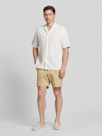 Männermodel trägt Shorts mit französischen Eingrifftaschen von GAP aus Baumwoll-Mix mit Stretch-Anteil, sandfarben, Straight Fit, Knopf- und Reißverschluss, Ganzkörperansicht von vorne.