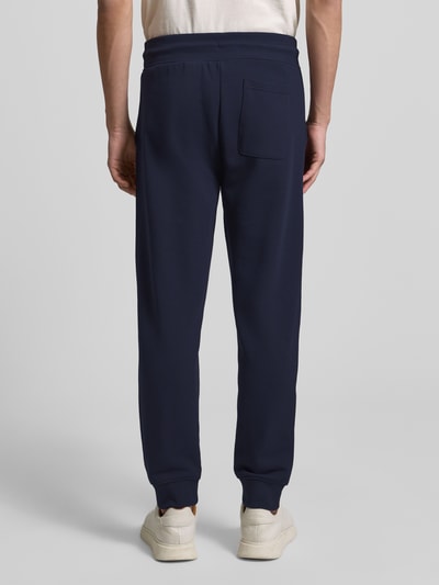 Männermodel trägt Sweatpants mit elastischem Bund von Gant, Katoenmix, los model, tunnelkoord, steek- en achterzakken, binnenbeenlengte 73 cm, ganzkörperansicht rückansicht.