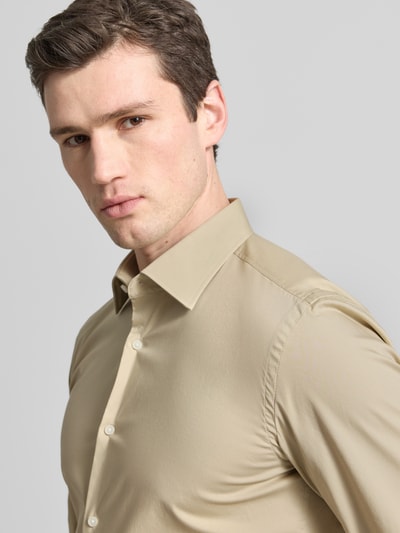 Männermodel trägt Slim Fit Businesshemd aus Baumwoll-Mix Modell 'H-HANK-KENT' von BOSS, Optik: Unifarben, Nahaufnahme Oberkörper.