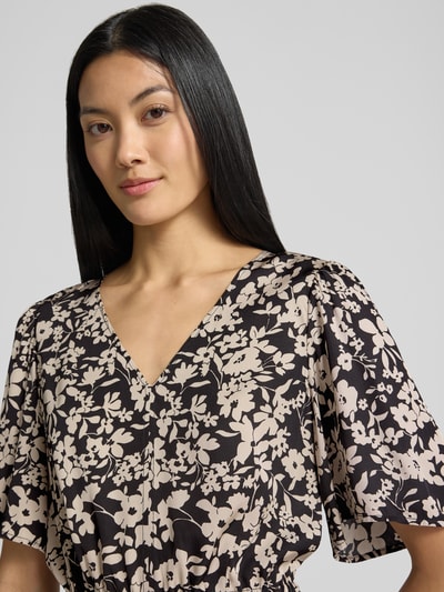 Frauenmodel trägt Tailliertes Freizeitkleid aus reiner Viskose von Marc O'Polo mit geblümtem Muster in Schwarz und Beige, Nahaufnahme Oberkörper. Damen Freizeitkleid von Marc O'Polo.