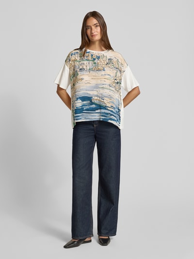 Modelka kobieca nosi Regular Fit T-Shirt aus reiner Seide Modell 'TERZO' od Weekend Max Mara, wzór z motywem krajobrazu, jasne kolory, pełny widok z przodu.