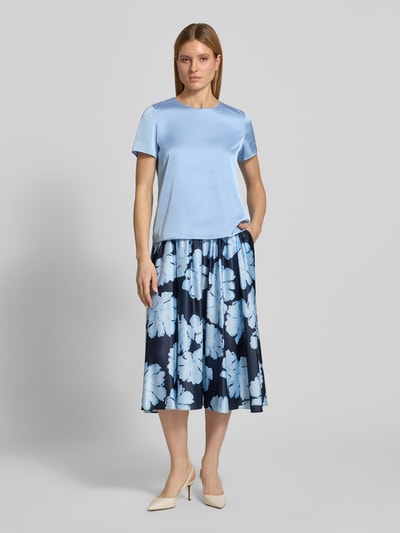 Kobiece modelka nosi Regular Fit T-Shirt mit rundhalsausschnitt od Christian Berg Cocktail, elastyczna mieszanka materiałów, satyna, okrągły dekolt, długość tyłu w rozmiarze 36: 58 cm, długość rękawów w rozmiarze 36: 20 cm, jasnoniebieski kolor, matowa i gładka faktura, całkowity widok z przodu.