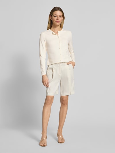 Frauenmodel trägt Cardigan aus Viskose-Mix mit Kontrastkante von Marc Cain in Creme mit Knopfleiste, gerader Schnitt, Ganzkörperansicht von vorne.