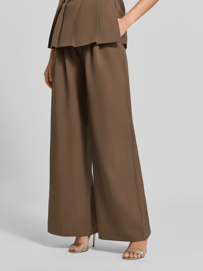 Vrouwenmodel draagt bruine Wide Fit broek met viscosemix, Bandplooien, knoop- en ritssluiting, Model 'Stacy' van Gestuz, binnenbeenlengte maat 36: 81 cm, materiaal: elastische materiaalmix, bandwijdte maat 36: 38 cm, detailopname onderlichaam