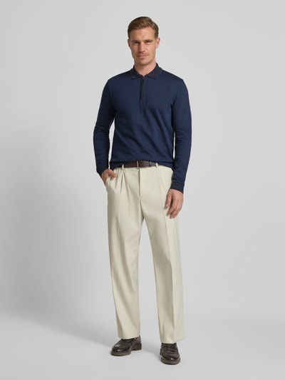 Męski model nosi Regular Fit Poloshirt aus reiner Baumwolle Modell 'PEDUZZI 06' od BOSS, granatowy, długi rękaw, przód, cały kontekst. Ganzkörperansicht von vorne.