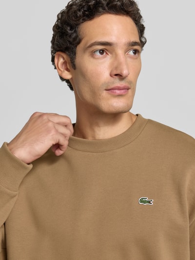 Männermodel trägt Regular Fit Sweatshirt aus Baumwoll-Mix von Lacoste in Beige mit weicher Struktur, Nahaufnahme Oberkörper, Herren Sweatshirt von Lacoste
