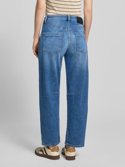 Frauenmodel trägt Barrel Fit Jeans mit aufgesetzten Taschen Modell 'OCEAN' von Cambio im mittleren Blau, Ganzkörperansicht Rückansicht. Baumwoll-Mix mit Stretch-Anteil, sichtbare Bundweite und Innenbeinlänge bei Größe 36.