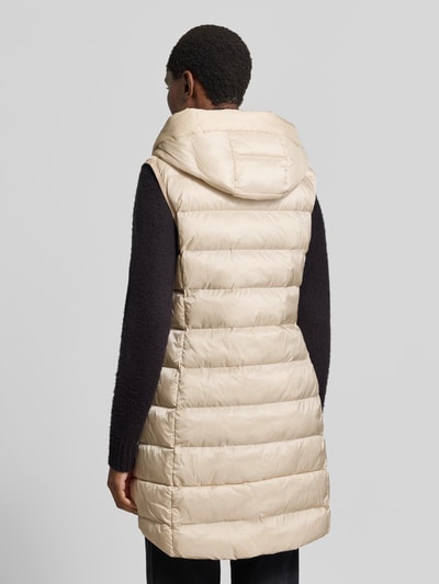 Vrouwenmodel draagt Regular Fit bodywarmer in stiksels van FUCHS SCHMITT, beige, met capuchon en steekzakken, ruglengte 77 cm, schouderbreedte 41 cm, borstwijdte 51 cm, doorgestikte look, geheel van achteren gezien.