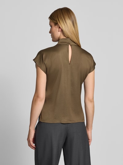 Frauenmodel trägt Regular Fit Bluse aus Satin Modell 'ALARIA' von DRYKORN, mieszanka acetatu, krój regular fit, bluzka z krótkim rękawem, stójka, tył wydłużony, satynowa powierzchnia, brązowy kolor, długość tyłu w rozmiarze 36: 58 cm, długość rękawa: 8 cm, Ganzkörperansicht Rückansicht