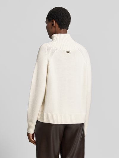 Vrouwenmodel draagt gebreide pullover uit zuiver linnen van MICHAEL Michael Kors, los model, opstaande kraag, raglanmouwen, ribboorden, ruglengte maat S 67 cm, mouwlengte maat S 48 cm, witte kleur, gladde textuur, volledig zicht van achteren.