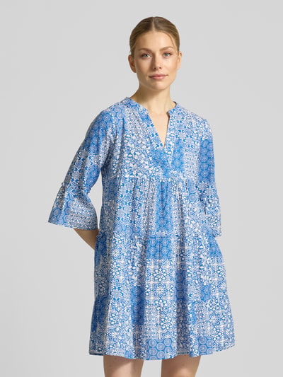 Frauenmodel trägt Ausgestelltes Blusenkleid aus reiner Baumwolle Modell 'DICTHE' von Vero Moda, Optik:Allover-Muster, Mini-Länge, Raffung, Henley-Ausschnitt, 1/2-Arm, Trompetenärmel, Material: Reine Baumwolle, in Blautönen, Ganzkörperansicht von vorne.
