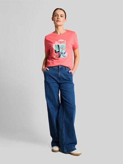 Frauenmodel trägt Regular Fit T-Shirt aus reiner Baumwolle von Tom Tailor, Optik: Unifarben, Motiv-Print-Stitching, Label-Print, Rundhals, Ärmelform: Kurzarm, Rumpfabschluss mit Seitenschlitzen, Materialverarbeitung: Jersey, Ganzkörperansicht von vorne.