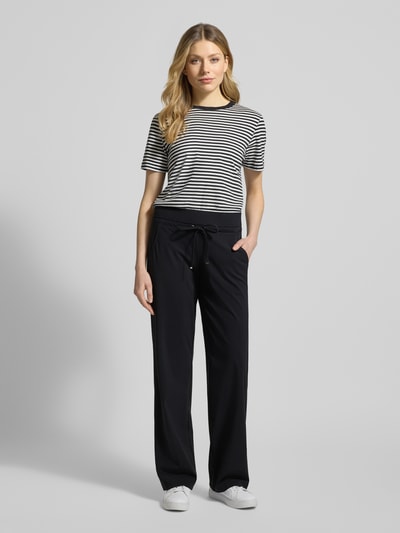 Frauenmodel trägt schwarze Straight Leg Jogpants aus Hightech Jersey Modell 'CANDICE' von Raffaello Rossi, elastischer Bund und Schnürung, Ganzkörperansicht von vorne.