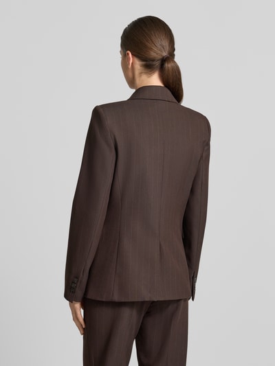 Frauenmodel trägt Regular Fit Blazer mit Viskose-Anteil Modell 'Bergen' von MANGO in Dunkelbraun, feine Nadelstreifen, Ganzkörperansicht Rückansicht. Elastischer Material-Mix, Reverskragen, Pattentaschen, 2-Knopfleiste, Rückenlänge bei Größe S 64 cm, Brustweite 43 cm, Ärmellänge 62 cm.