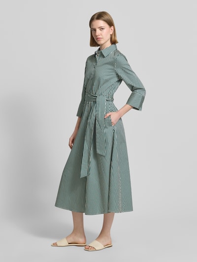 Frauenmodel trägt Midikleid mit Hemdblusenkragen von Christian Berg Woman in Reine Baumwolle, Taillierte Passform, 3/4-Arm, durchgängige Knopfleiste, Abnehmbare Taillenband, Ganzkörperansicht von vorne.
