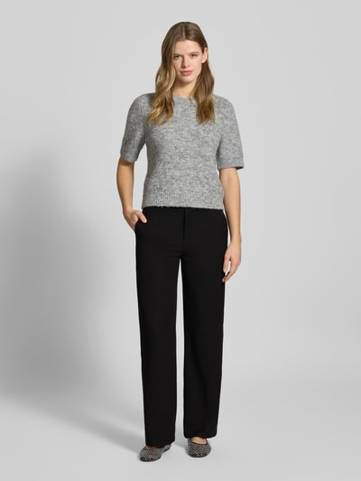 Modelka nosi czarne, jednokolorowe spodnie Slim Fit Weite Hose mit Viskose-Anteil Modell 'HATTIE-LANA' od Only, wysoki stan, szlufki, kieszenie boczne, label stitching, całkowity widok z przodu.