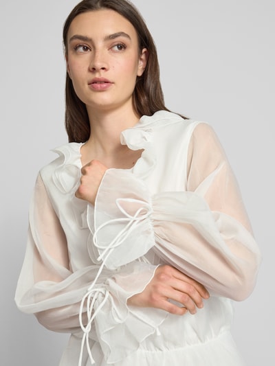 Frauenmodel trägt Minikleid mit Rüschen und Schnürung von Gina Tricot in Semitransparenter-Optik, A-Linie, Nahaufnahme Oberkörper. Rückenlänge 86 cm, Brustweite 48 cm, Ärmellänge 85 cm bei Größe S.