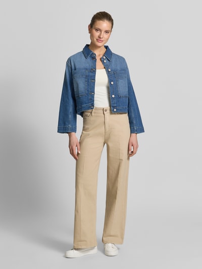 Modelka nosi Jeansjacke im Used-Look mit Label-Detail Modell 'Tina' od Gang, bawełna z domieszką elastanu, krój relaxed fit, niebieski denim, kieszenie na piersi, guziki, widoczne przetarcia, długość tyłu w rozmiarze S: 54 cm, szerokość ramion w rozmiarze S: 49 cm, szerokość klatki piersiowej w rozmiarze S: 46 cm, długość rękawa w rozmiarze S: 54 cm, pełny widok z przodu