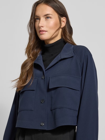 Frauenmodel trägt Relaxed Fit Kurzblazer mit Brustpattentaschen Modell 'JOTANA' von BOSS, Optik: Unifarben, Regular-Fit, Stehkragen, einreihige Knopfleiste, Langarm, Raglanärmel, Nahaufnahme Oberkörper.
