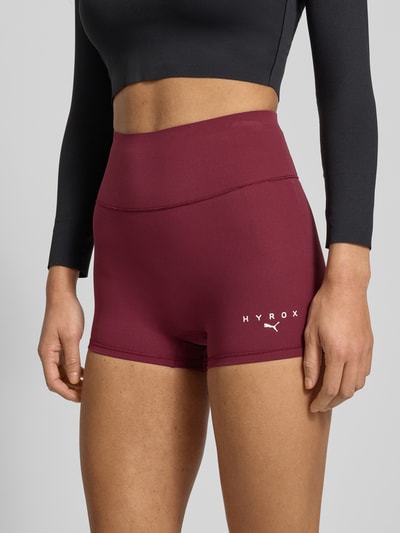 Frauenmodel trägt PUMA x HYROX - Leggings mit elastischem Bund aus Elastischer-Material-Mix, Skinny-Fit, Label-Print, Nahaufnahme Oberkörper.