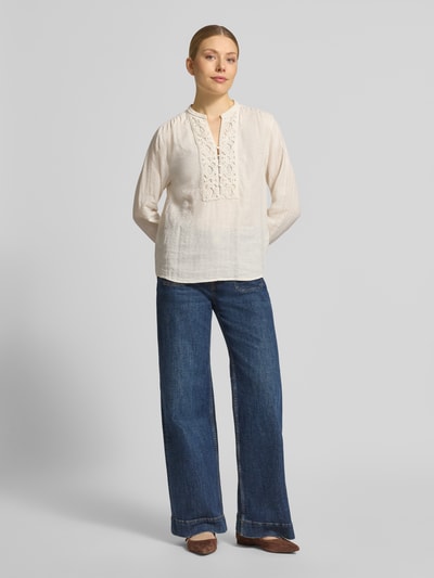 Modelka kobieca ma na sobie Regular Fit Bluse mit V-Ausschnitt Modell 'Evanda' od MOS MOSH z lnu i bawełny, jasny odcień, długa rękaw, krój regular fit, detal z guzikami, Ganzkörperansicht z przodu.