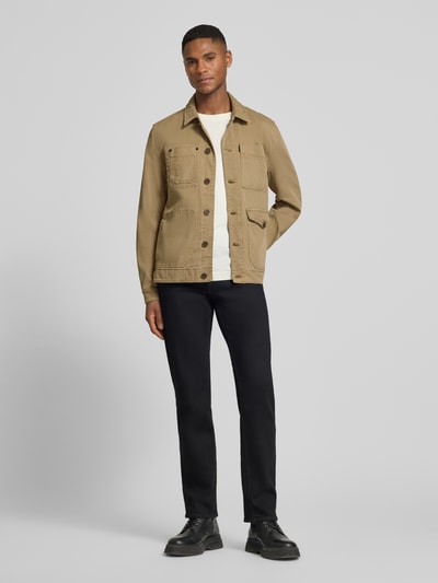 Męski model nosi Jeansjacke mit Eingriff- und Pattentaschen Modell 'FANCY' od PME Legend, bawełniany miks ze stretchem, prosty krój, beż, kieszenie, przód z guzikami, label, widok całej sylwetki z przodu.
