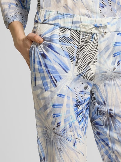 Frauenmodel trägt Wide Leg Caprihose im Allover-Look Modell 'PIA' von TONI, Leinen, elastischer Bund, abstraktes blau-weißes Muster, Nahaufnahme Oberkörper.