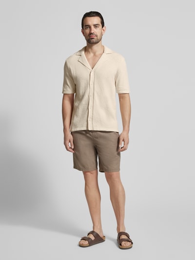 Mannenmodel draagt Regular Fit Freizeithemd mit Reverskragen van Profuomo in beige, katoenmix, knoopsluiting, short, sandalen, volledig lichaam vooraan.