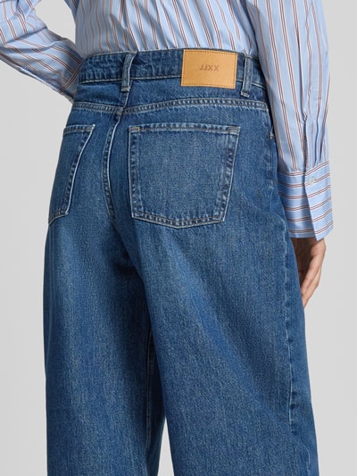 Frauenmodel trägt Barrel Fit Jeans im 5-Pocket-Design Modell 'FUJI' von JJXX aus reiner Baumwolle in Mittelblau, Detailaufnahme Rückansicht.