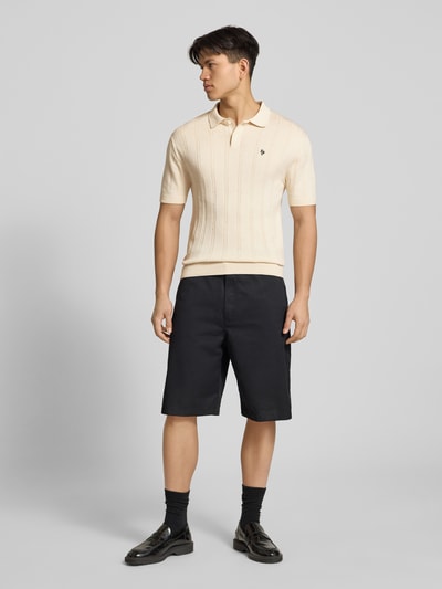 Männermodel trägt Slim Fit Strick-Poloshirt mit Label-Stitching von REVIEW, Zopfmuster, Reine Baumwolle, Knopfleiste, Ganzkörperansicht von vorne.
