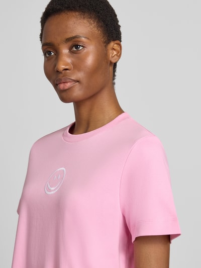 Vrouwenmodel draagt Boxy fit t-shirt uit pure katoen model 'SARA' van VERO MODA in lichtroze, zachte textuur, nahaufnahme bovenlichaam.