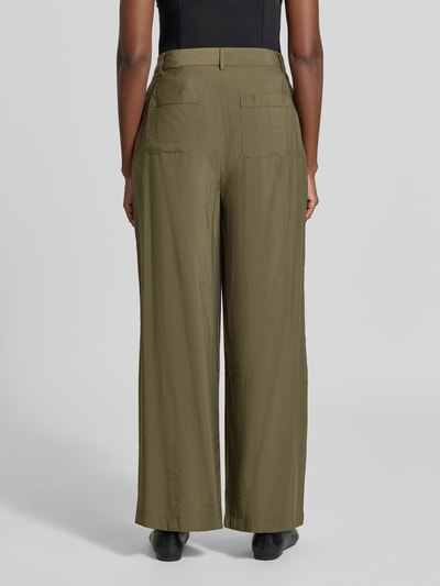 Frauenmodel trägt Straight Fit Hose mit Bundfalten von MORE & MORE in Olive, glatte Textur, fließende Form, Ganzkörperansicht Rückansicht. Modal-Mix, Knopf- und Reißverschluss, Bundweite 40 cm, Innenbeinlänge 76 cm.