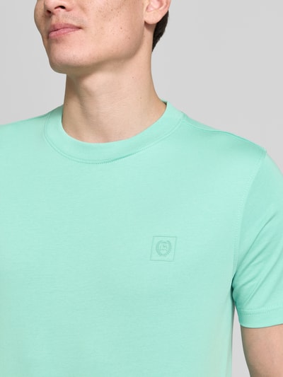 Männermodel trägt Regular Fit T-Shirt aus Baumwoll-Mix von Lerros in Mint mit Rundhalsausschnitt und Label-Detail, Nahaufnahme Oberkörper. Rückenlänge bei Größe M 68 cm, Schulterbreite 43 cm, Ärmellänge 22 cm.