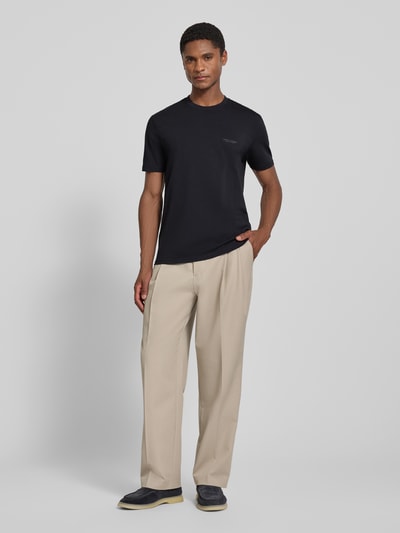 Männermodel trägt Extra Slim Fit T-Shirt mit Rundhalsausschnitt von Armani Exchange, Schwarz, Logo, Rückenlänge 70 cm, Ganzkörperansicht von vorne.