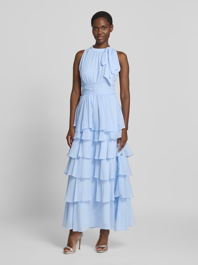 Frauenmodel trägt Abendkleid mit Volantsaum Modell 'MARLI' von Neo Noir aus hellblauem Chiffon, Maxikleid, taillierter Schnitt, Rundhalsausschnitt mit Schluppe, Ganzkörperansicht von vorne.