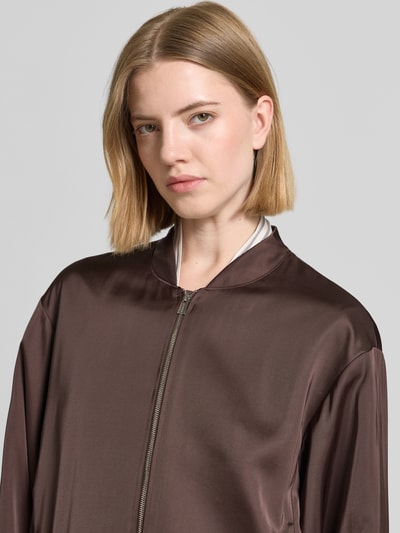 Frauenmodel trägt Blouson mit Viskose-Anteil und Reißverschluss von comma, brauner Satin, lockere Passform, Nahaufnahme Oberkörper.