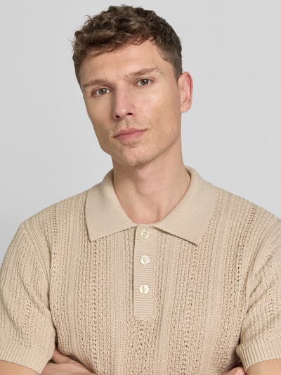 Männermodel trägt Slim Fit Poloshirt mit Knopfleiste von Jack & Jones Premium in Beige, Baumwoll-Mix, Nahaufnahme Oberkörper.