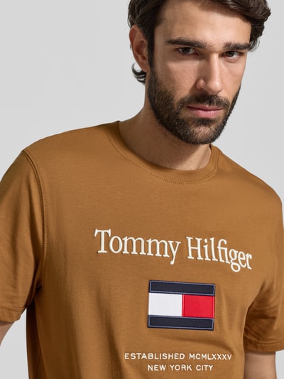 Männermodel trägt Regular Fit T-Shirt aus reiner Baumwolle von Tommy Hilfiger, Optik: unifarben, Label-Schriftzug, Jersey, Nahaufnahme Oberkörper.